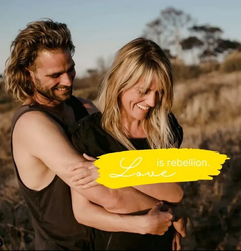 Lachendes Paar in der Natur, Schriftzug: Love is rebellion